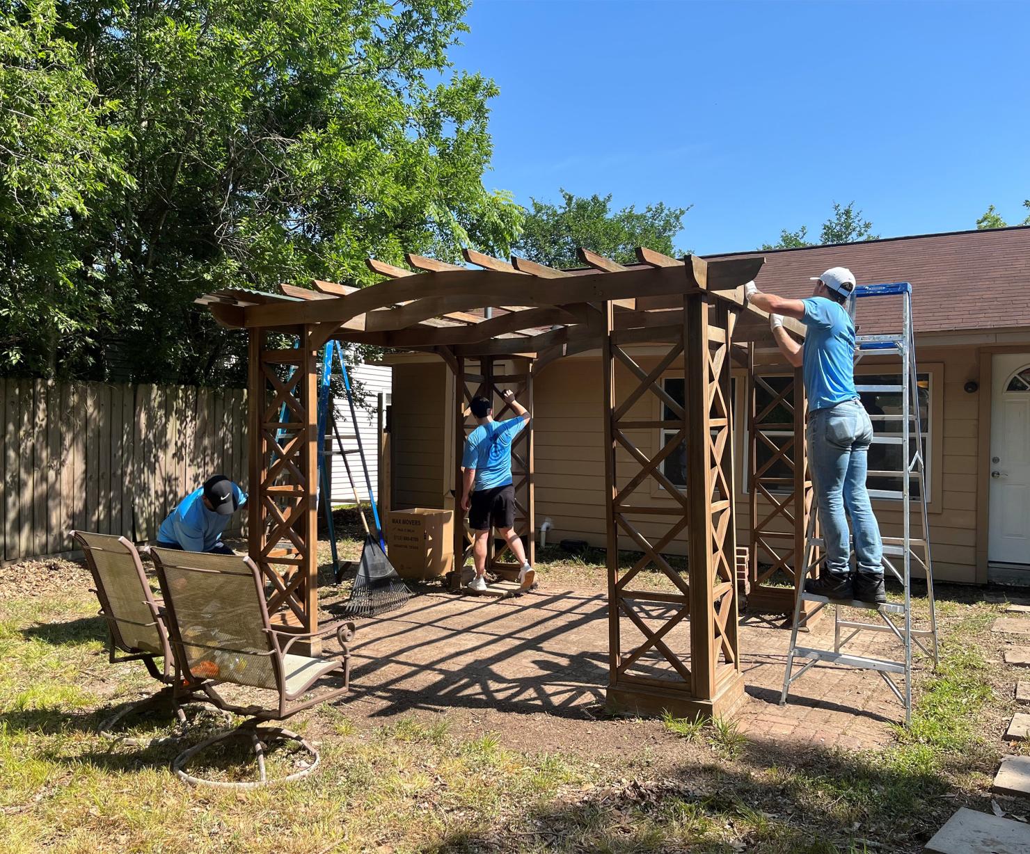 EnCap employees make repairs to the home’s backyard gazebo.