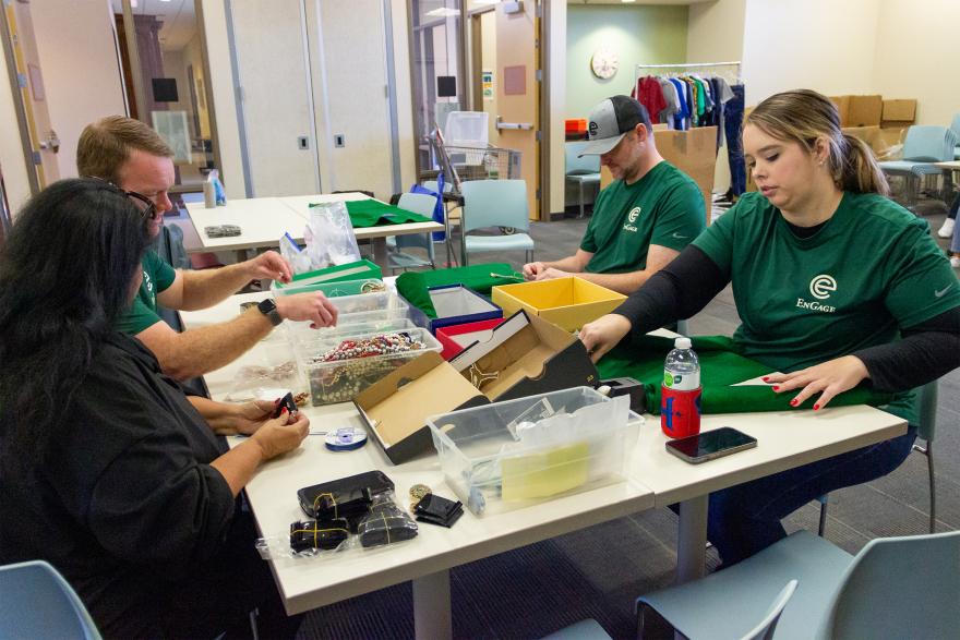 Ryan Devlin (L), Cole Sanches (M) and Aubrey Crawford (R) sort and price jewelry donation for MAM’s resale shop.